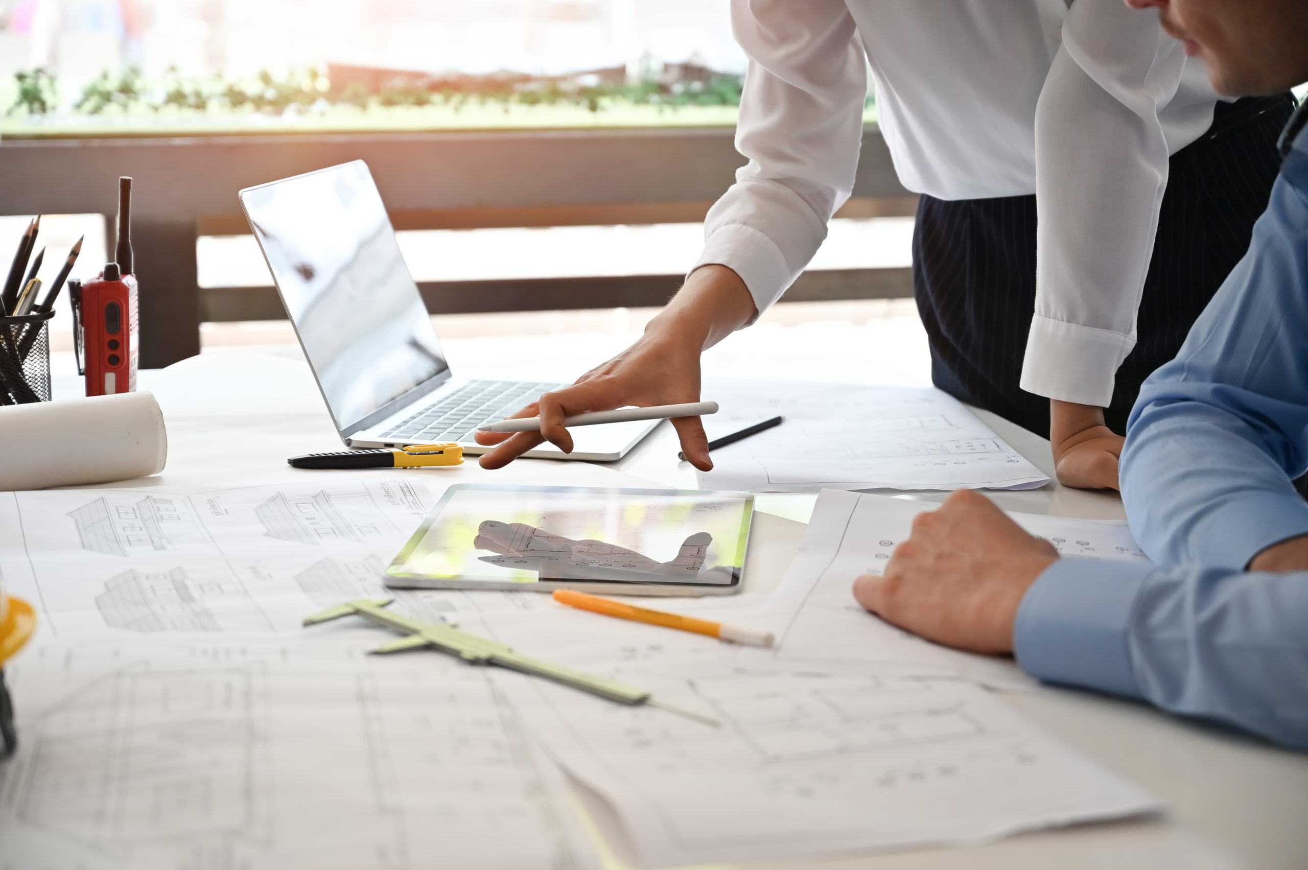 Team architect meeting and consult with blueprint and computer i